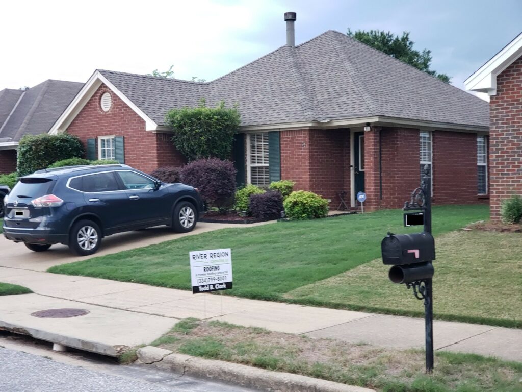 home with asphalt shingles and river region contracting sign in yard