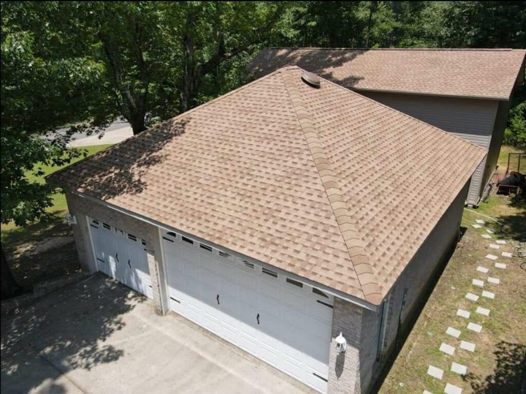aerial view of home with roof shingles on garage