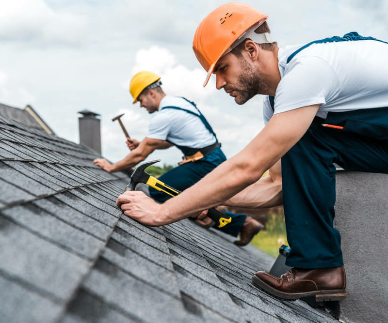 roofers nailing shingles into roof